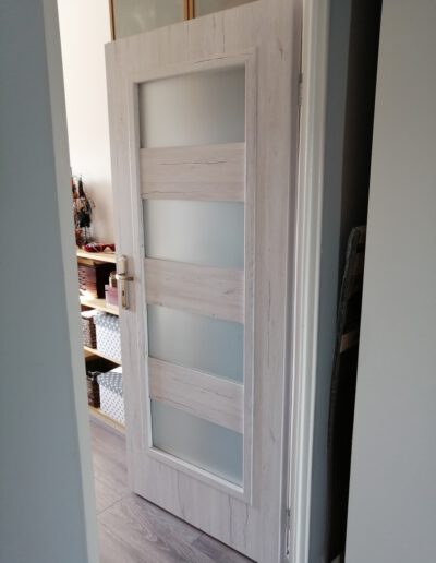 Jasne drewniane drzwi z matowanym przeszkleniem