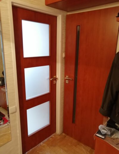 Montaż dwóch czerwonych drzwi do wnętrz z matowym przeszkleniem